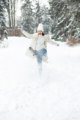 Merry woman playing with snow at the park