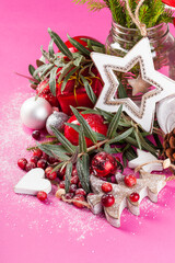 Bright Christmas decorations with fresh cranberries on a paper crimson background.
