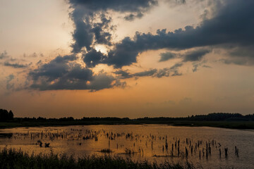 lake during sunset with yellow-orange sky