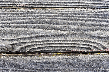 Wood plank grain with white frost crystals.