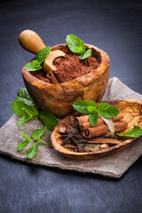 Сocoa  in wooden bowl and spices - cinnamon, cardamom, tubby. Candy set. Sweet life.