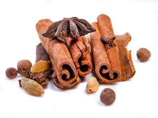 Cinnamon sticks and spieces close up on wooden table. Dark style