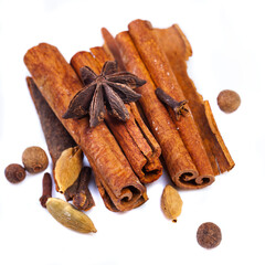 Cinnamon sticks and spieces close up on wooden table. Dark style