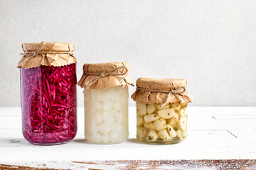 Various canned autumn vegetables in glass jars. Marinated mushrooms, garlic, champignon, onion, red...