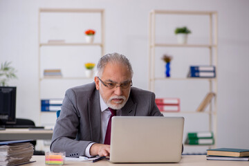 Fototapeta premium Old male employee sitting in the office