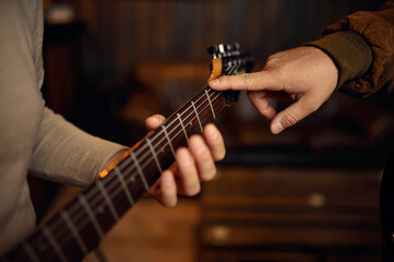 Closeup hand of male musician playing guitar