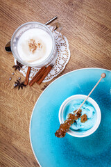 Fragrant spices, coffee, cinnamon and marshmallow on turquoise ceramic plate.Top view.