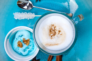 Fragrant spices, coffee, cinnamon and marshmallow on turquoise ceramic plate.Top view.