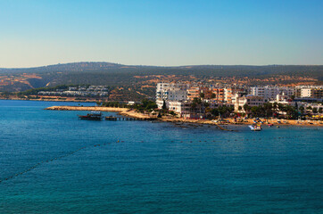 Kizkalesi, Turkey-October 11,2021:Wide angle landscape view of blue water of Mediterranean Sea and city beach, embankment with many hotels in Kizkalesi. Blue sky background. Famous touristic place