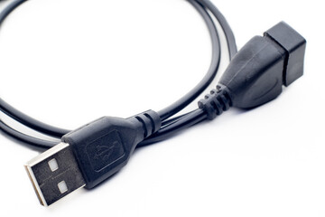 Black usb type-A male and female cable on a white background with a symbol in one of the connections, you can see part of the cable and the two connectors with the gold metal terminals.