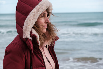 Baby Boomer woman with coat in winter on the  beach