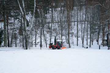 snow removal in the nature park with a tractor in winter
