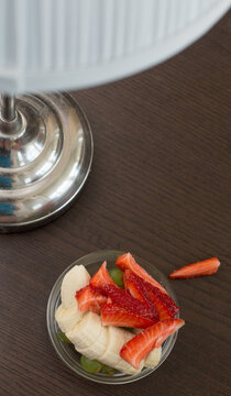 Wholesome Strawberry, Banana, and Grapes. Near the lamp. Dark Background