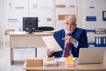 Old male employee working in the office