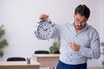Young male teacher in time management concept