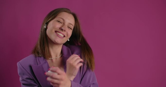 Happy woman dances while listening music in bluetooth headphones, 4k Prores HQ 60fps