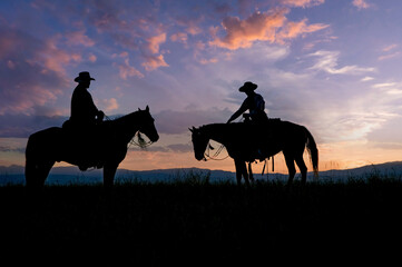 Fototapeta na wymiar Two cowboys on horseback silhouette