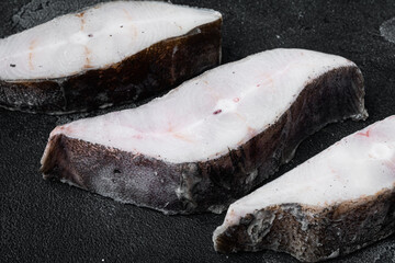 Frozen fish cut, on black dark stone table background