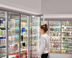 Woman choosing frozen food from a supermarket freezer.