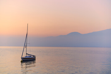 boat moored on a large lake while a beautiful sunset