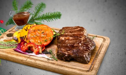 Christmas dinner for two, grilled beef steak, ribeye, greens and spices with a Christmas tree