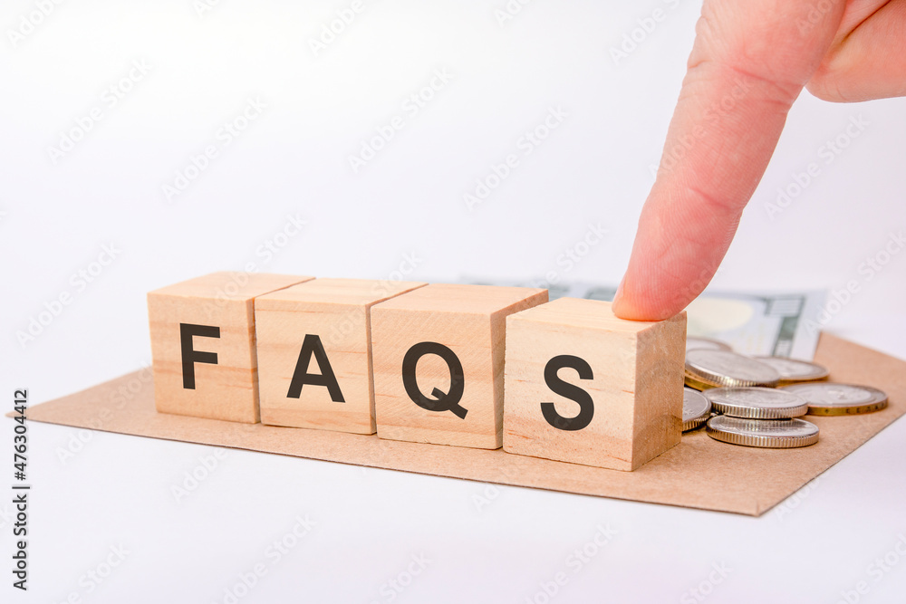 Aufkleber hand holding wooden cube blocks with faq text - frequently asked questions- on table background. fin