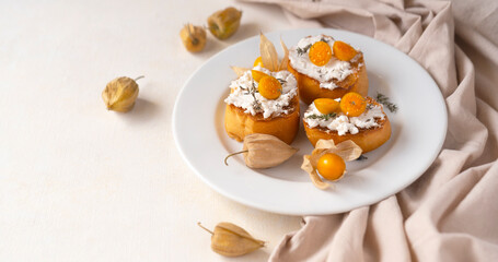 Ricotta Crostini topped with cape gooseberries on a white plate, copy space. Tropical fruit and food for health concept.