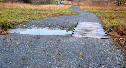 The dirt road leads across a stream that crosses river and continues when the flood road is impassable. restoration of watercourses relocation upright drainage of fields into meandering , ford