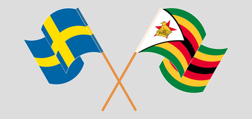 Crossed and waving flags of Sweden and Zimbabwe