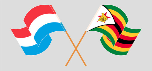 Crossed and waving flags of Luxembourg and Zimbabwe