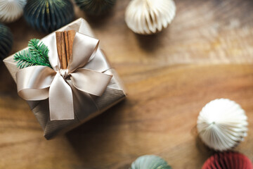 A beautifully wrapped Christmas present with natural decor on a wooden background.