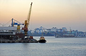 Obraz premium Tugboat and port cargo crane