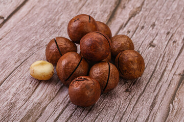 Brown macadamia nut heap over background