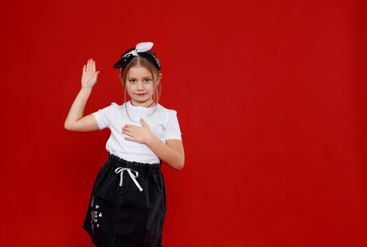 Portrait of a beautiful little girl posing on an isolated red background.