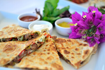 quesadillas with sauces on white dish