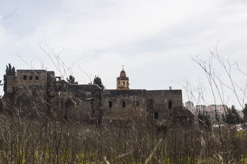 Side view of the monastery of the cross through bare branches in Jerusalem