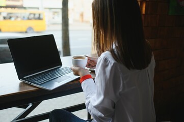Beautiful Caucasian woman dreaming about something while sitting with portable net-book in modern cafe bar, young charming female freelancer thinking about new ideas during work on laptop computer