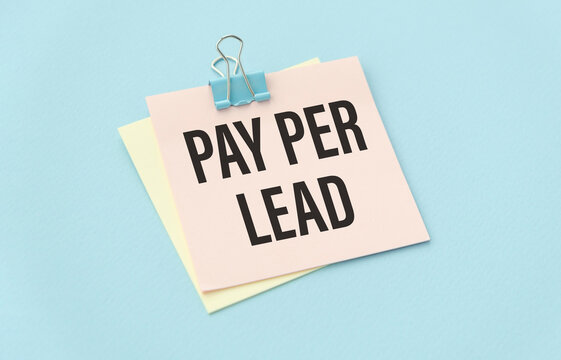 PAY PER LEAD text on white paper on blue background.