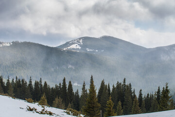 Winter mountains with snow under a dark winter sky.