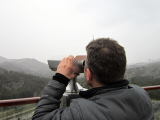 Obraz premium Young Man Looking From Above Through Binoculars 