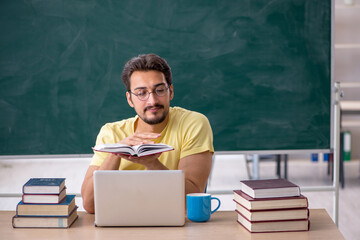 Young male student preparing for exams in the classroom