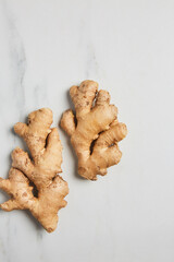 Overhead view of ginger on a white marble background