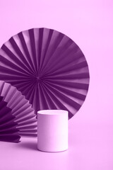 White podium red paper fan background for branding and product presentation. Vertical format. toning in very peri monochrome color