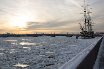 Frozen Neva river with ice, ship, bridge and panorama of St. Petersburg in the background