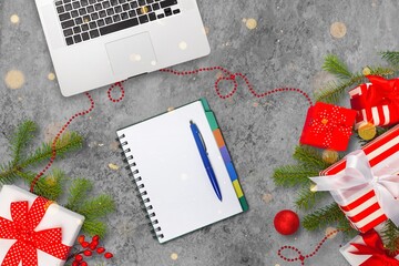 Christmas online shopping, a notebook for a shopping list. Laptop, present box on the desk