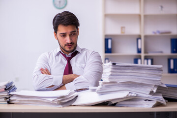 Young businessman employee unhappy with excessive work in the office