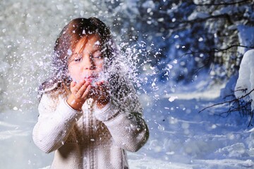 Baby playing with the snow, winter time. Children play in a snowy park