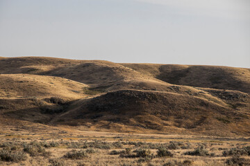 Rolling hills at sun set before a storm at Grasslands National Park, Canada