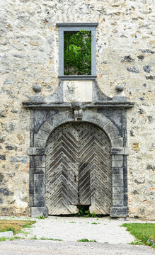Splendid old doors in the stone wall, a part of the decayed castle