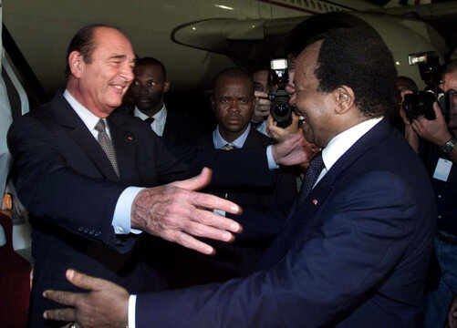 French President Jacques Chirac (L) opens his arms to embrace Cameroon President Paul Biya (R) as Ch..